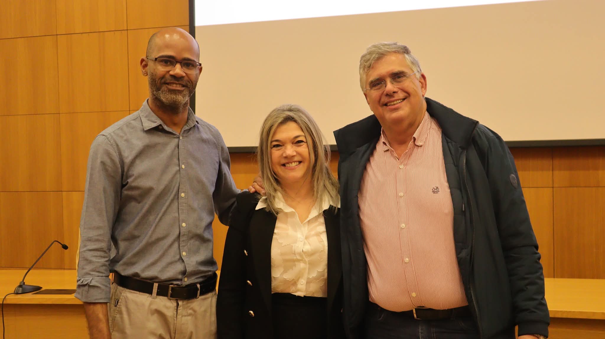 Três pessoas numa sala de conferência